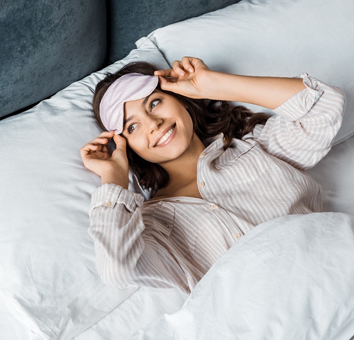 Woman waking up refreshed after good night of sleep