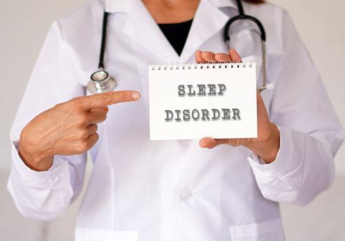 Medical professional pointing at sign that says “sleep disorder”