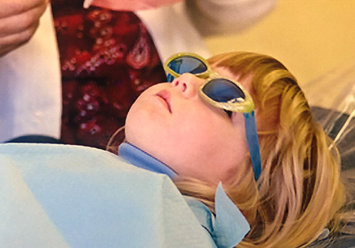 Little girl with sunglasses on in dental chair