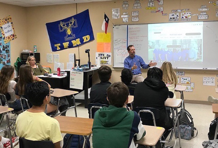 Dr. Butler talking to class of school children