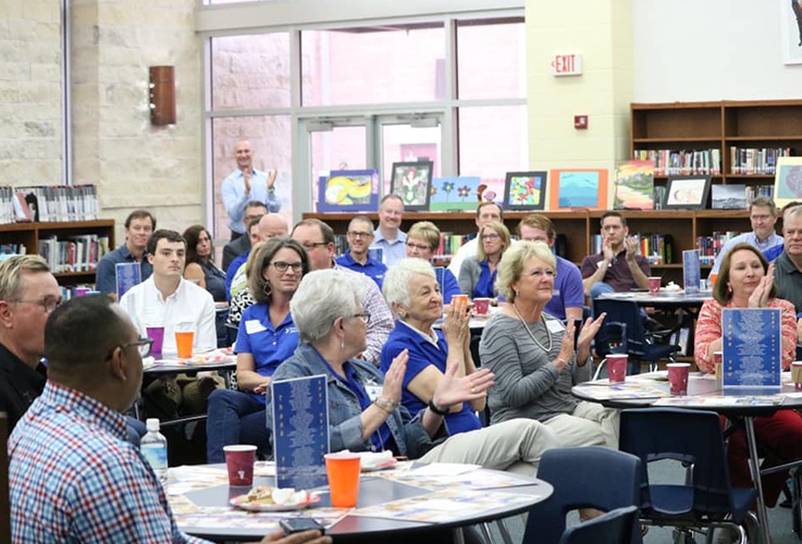 Group of people at community event clapping