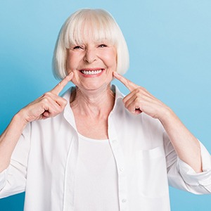 Senior woman pointing to mouth and smiling