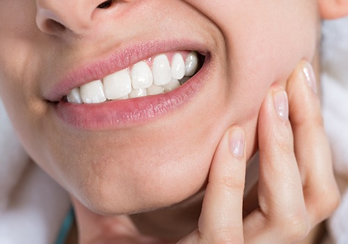 Person in need of tooth extraction holding jaw in pain