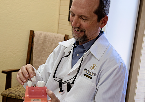 Dr. Butler showing dental implant model