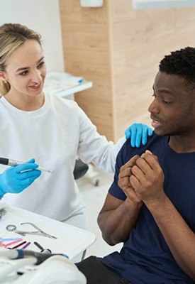 Dentist reassuring a nervous-looking patient