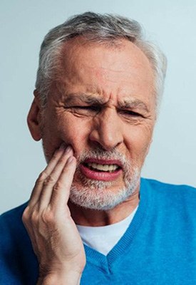 Man rubbing his jaw and wincing
