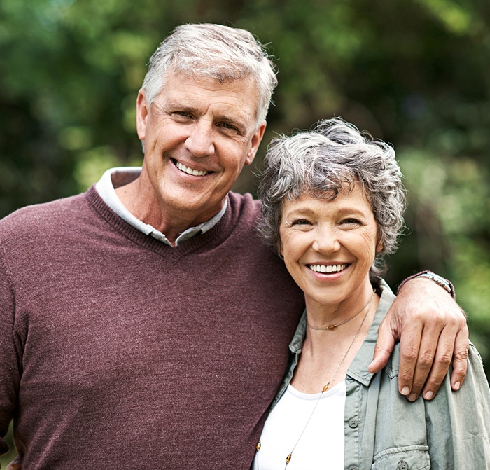 Older man and woman with healthy smiles after periodontal therapy