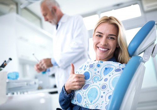 woman giving thumbs up in dental chair 
