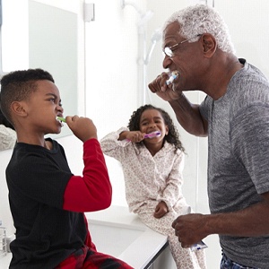 Man brushing teeth with grandkids in Kerrville