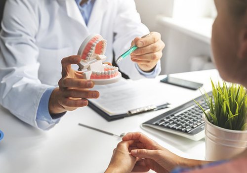 a dentist explaining the cost of a full mouth rehabilitation