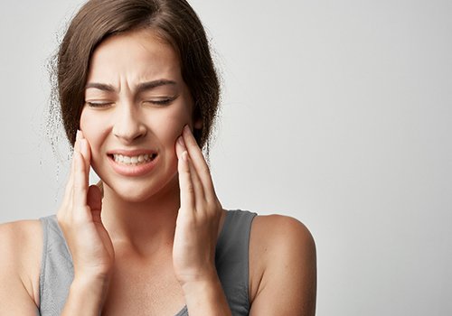 Grimacing woman with jaw pain