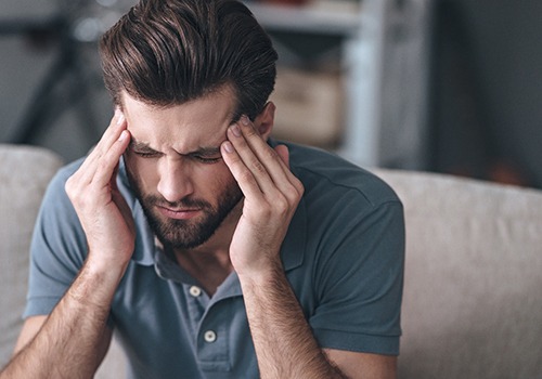 Man experiencing headache due to TMJ disorder