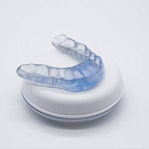 Occlusal splint on top of its storage case