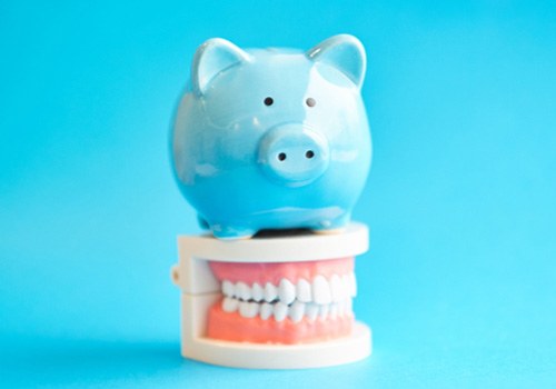  A piggy bank sitting on a model of teeth