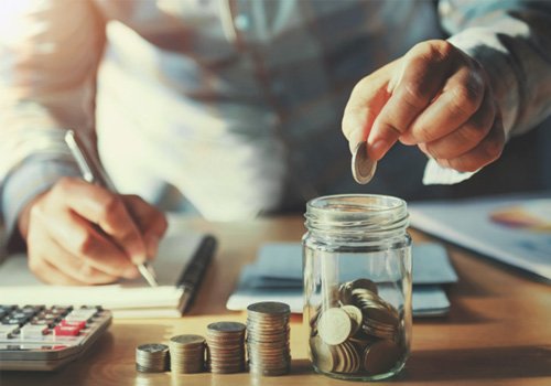 Person putting coins into a jar