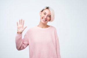 Smiling woman waving at her Kerrville, TX dentist