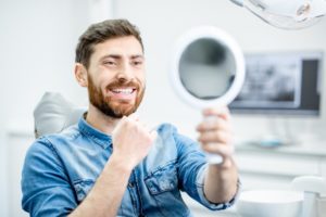 dental patient seeing his new smile after a full-mouth rehabilitation