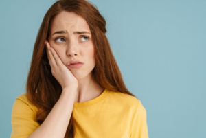 Stressed woman holding her aching jaw