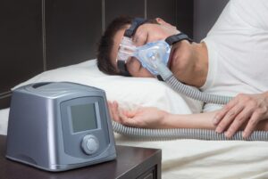 Man sleeping, wearing CPAP mask.